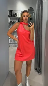 Vestido corto de satén color coral, con un solo hombro y corte holgado.