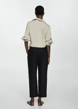 Pantalón negro de lino con diseño crop y jogger, tiro medio, cintura elástica con lazo, dos bolsillos laterales y dos bolsillos de ribete en la parte posterior.