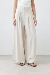 Pantalón palazzo color beige melange de tiro alto con pinzas delanteras y corte amplio.