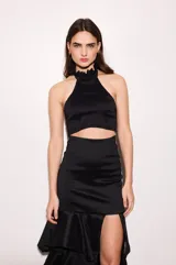 Falda larga negra de tafeta con cintura ajustada, tajo lateral y volados escalonados.