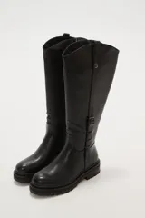 Bota alta de caña ancha color negro, con cierre lateral y detalle de hebilla ajustable en la parte superior de la caña. Suela de goma gruesa con relieve.
