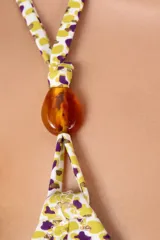 Top de bikini con estampado de leopardo en tonos amarillo y violeta. Tiene forma triangular, tirantes finos con cuentas y cierre con lazo.