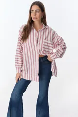 Camisa blanca con rayas verticales rojas, de corte holgado, manga larga y bolsillo en el pecho.