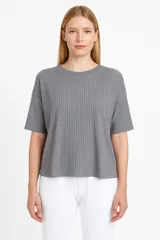 Remera gris de poliéster, de manga corta, corte holgado y cuello redondo.