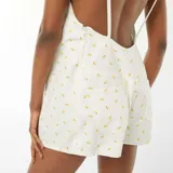 Mono corto blanco con estampado de limones amarillos, breteles finos y espalda descubierta.