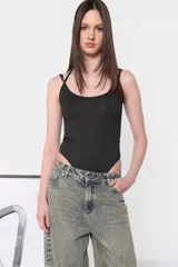 Body blanco de microfibra al cuerpo con tiras finas superpuestas en escote y espalda. Broches snap en entrepierna y elástico interno en contorno de tiro.