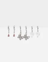 Set de tres pares de aros argolla plateados con dijes colgantes: gota rosada, mariposa con strass y corazón transparente.