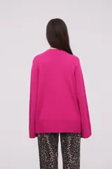 Sweater color fucsia, de corte holgado y manga larga.