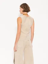 Top color beige confeccionado en tejido de algodón con cuello a la base y recortes de entalle.