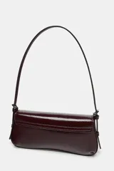Bolso de hombro color crema con efecto acharolado, solapa con cierre imantado y asa ajustable.