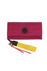 Billetera Trendy color fucsia con cierre de solapa y botón a presión. Incluye correa de mano amarilla y dije de cuerda rosa y naranja.