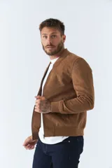 Campera marrón de gamuza para hombre, con cuello mao, cierre frontal con cremallera, bolsillos laterales y puños ajustados.