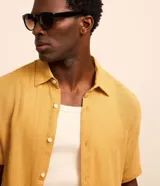 Camisa masculina de manga corta, cuello inglés y abotonado delantero, confeccionada en algodón con textura. Presenta un calce comfort más holgado.