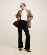 Pantalón negro de punto roma, corte flare, con bolsillos delanteros de solapa y bolsillos traseros embutidos.
