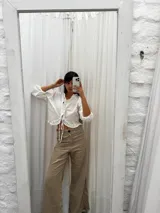 Blusa color blanco de lino, con mangas 3/4 y volados en el frente. Se ata con lazos en el centro.