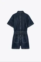 Mono corto de denim azul oscuro, con cuello solapa, manga corta, bolsillos delanteros y traseros, cintura elástica en la espalda y cierre frontal con cremallera y botones metálicos.
