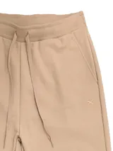 Pantalón de jogging color beige, de corte babucha, con cintura y tobillos elastizados y cordón ajustable.
