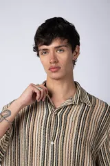 Camisa de manga corta con cuello solapa, corte holgado y estampado de rayas verticales en tonos beige, negro y rojo.