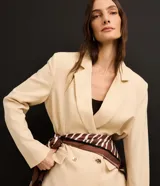 Blazer oversized color beige confeccionado en viscolino, con solapas en el cuello, botones delanteros y solapas delanteras que simulan bolsillos.