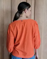 Blusa color rosa con mangas 3/4 y cuello redondo.