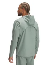 Campera deportiva Under Armour Outrun The Storm, color verde agua, con capucha, cierre frontal completo y logo estampado en amarillo flúor.