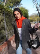Blazer oversize de tweed a cuadros en tonos grises, con solapas amplias, cierre cruzado con botones strass y pin dorado en forma de salchicha.