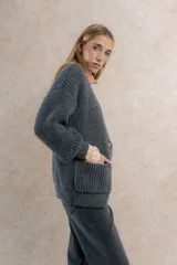 Saco de lana color verde oliva, con silueta oversize, mangas balloon, punto perlado y cuello en V.