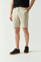 Bermuda de lino y algodón color beige, con bolsillos laterales y traseros, cierre con botón y presillas para cinturón.