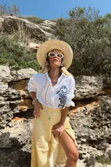 Camisa blanca de lino con bordado de pulpo azul en el pecho, de corte recto y manga larga.