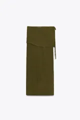 Falda larga color verde oliva, de tiro medio y corte recto. Presenta una superposición de tela tipo pareo ajustable con lazadas.