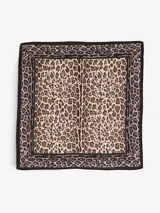 Pañuelo cuadrado de seda color beige con estampado animal print en tonos marrón y negro.