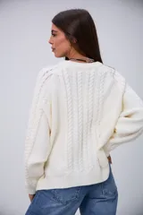 Sweater blanco de punto trenzado, con cuello redondo y mangas largas.