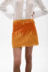 Minifalda color mostaza con lentejuelas y cierre trasero.