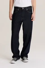 Pantalón de jean azul oscuro, corte amplio, con bolsillos delanteros y traseros.