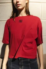 Remera negra de algodón con corte cuadrado, cuello redondo y logo bordado en color naranja.
