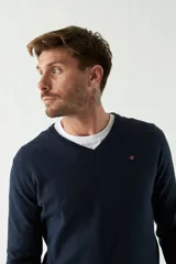 Sweater negro de manga larga con escote en V y logo bordado.