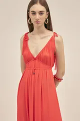 Vestido largo color coral, sin mangas, confeccionado en crepe. Presenta breteles finos que se atan para regular el largo y dos tiras en el pecho que se pueden atar de diferentes maneras.