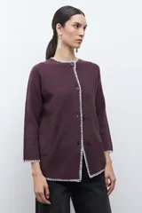Saco de punto color ciruela oscuro, de manga larga y cuello redondo, con cierre frontal de botones y ribetes en contraste blanco con puntada decorativa.