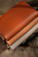 Billetera negra de cuero con cierre de cremallera, múltiples ranuras para tarjetas, compartimento para billetes y monedero con cremallera.