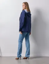 Campera impermeable azul con cierre central, bolsillos delanteros y lazo de ajuste en la cintura. Tiene avíos metálicos plateados y cierre oculto en la espalda para autoguardado.