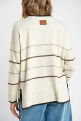 Sweater color crema con rayas horizontales en tonos marrón, bordeaux y beige.