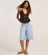 Blusa marrón oscuro con textura plisada, estilo frente única (halter) con escote en V profundo y lazo ajustable en el centro del busto. Presenta un ruedo con volado o efecto nube.