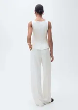 Top blanco con cuello barco y bajo con vuelo.
