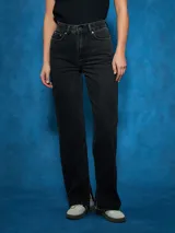 Jean de tiro alto, color negro lavado, de corte recto y pierna ancha. Presenta un ligero desgaste en el lavado y un pequeño tajo en el ruedo interior de la pierna.