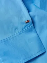 Camisa celeste de popelín de algodón orgánico, corte oversize con hombros caídos, cuello inglés, bolsillo de parche en el pecho y logo bordado en la manga.