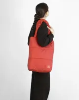 Bolso tote negro acolchado con doble asa de hombro.