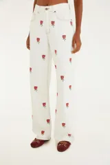 Pantalón blanco de sarga de pierna ancha con bordado floral de rosas rojas. Presenta un corte holgado y cintura alta.