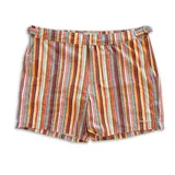 Short de baño con estampado de rayas horizontales y motivos geométricos en tonos naranja, marrón y blanco. Cuenta con pretina elástica y cordón ajustable.