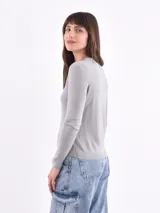 Sweater gris de tejido de punto fino, con cuello redondo y mangas largas.