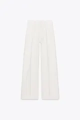 Pantalón de jean blanco de tiro alto, corte wide leg y relaxed fit. Con trabillas en la cintura, bolsillos delanteros y traseros, raya planchada en el frente y cierre frontal con cremallera, botón interior y gancho metálico.